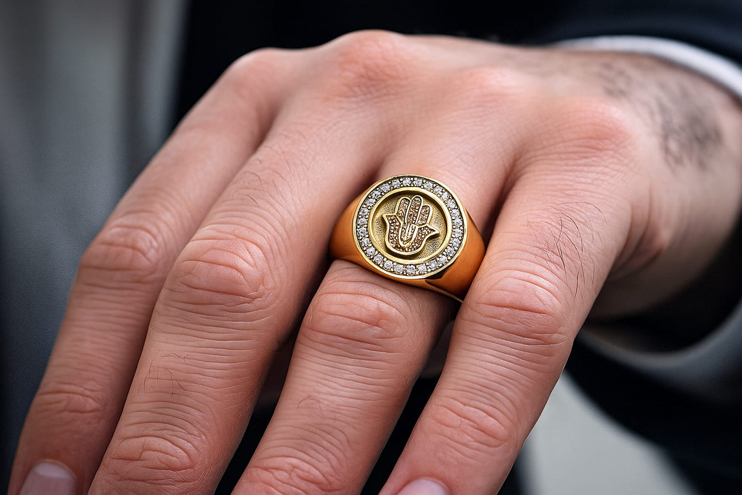 Gold ring with a diamond-encrusted design on a person's finger.